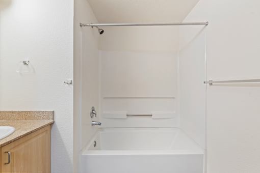 A white bathroom with a tub and sink.