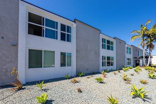 A white building with a gravel area in front of it.