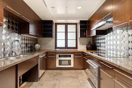 A kitchen with brown cabinets and a tiled backsplash.