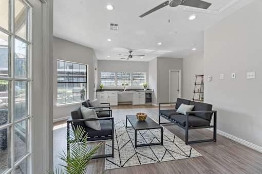 A modern living room with a black sofa and a glass door.