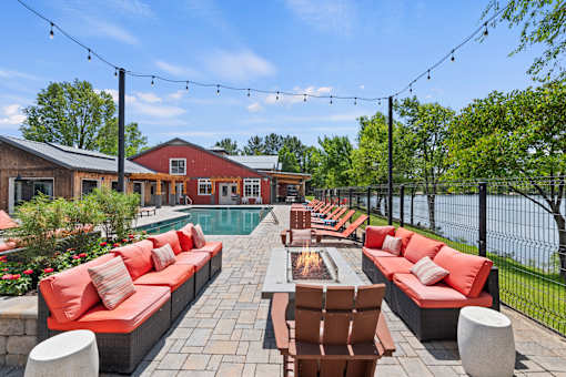 A patio with red couches and a fire pit.