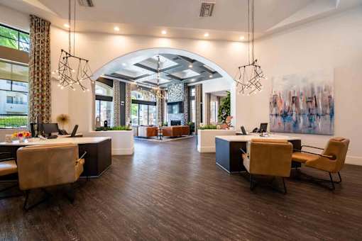 A modern office space with wooden floors and a large painting on the wall.