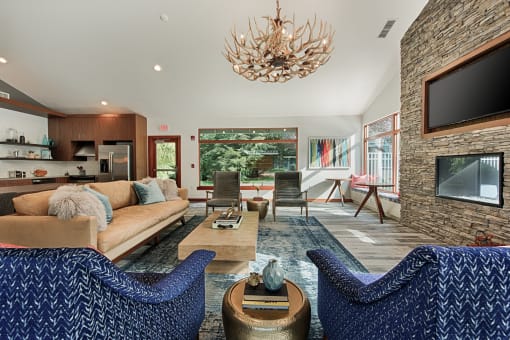 Lounge with blue patterned chairs and antler chandelier at Canyon Creek Apartments, Wilsonville, OR