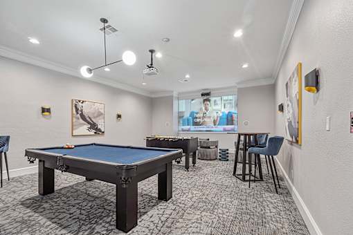 A room with a pool table and a television.