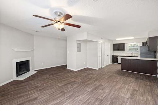 A living room with a fireplace and a ceiling fan.