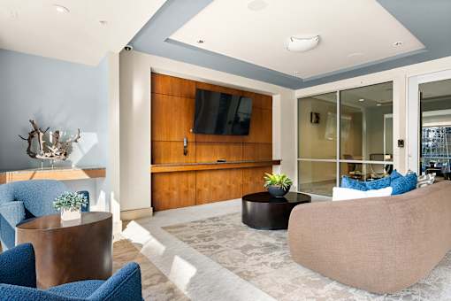 A living room with a blue accent wall and a wooden entertainment center.
