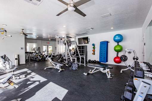 A well-equipped gym with a variety of exercise machines and weights.