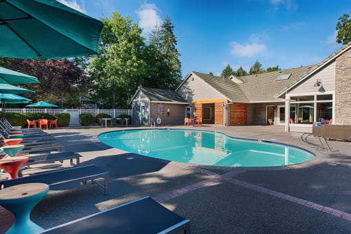 Outdoor swimming pool with surrounding patio furniture at Canyon Creek Apartments, Wilsonville, Oregon