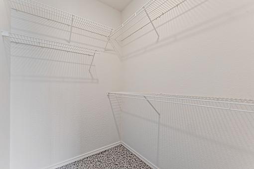 Empty white refrigerator with shelves and racks.