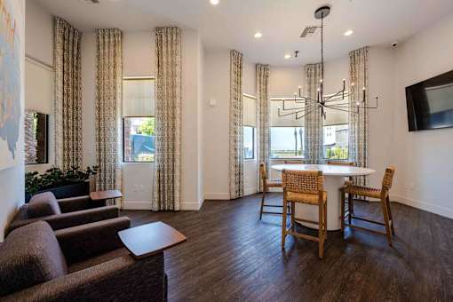 A living room with a brown sofa, a white table, and a chandelier.