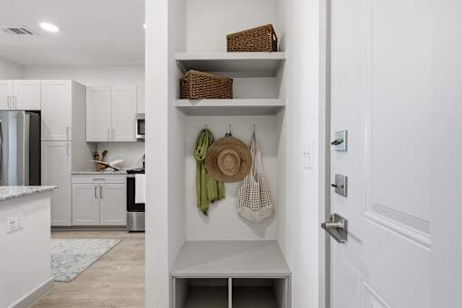 A kitchen with white cabinets and a white door.