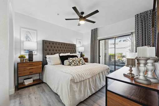 A bedroom with a large bed and a ceiling fan.