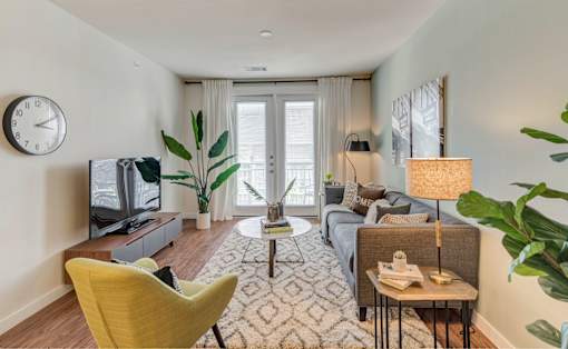 A living room with a yellow chair and a television.