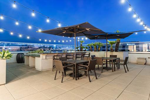 A patio with a table and chairs under a canopy of lights.