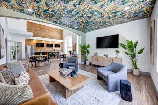 Clubhouse lounge with a wooden coffee table and a grey armchair.