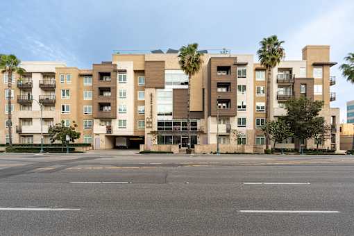 A large apartment complex with a parking lot in front.