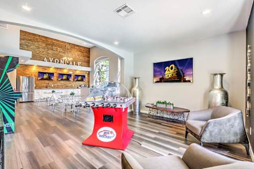 A room with a wooden floor and a red booth in the middle.