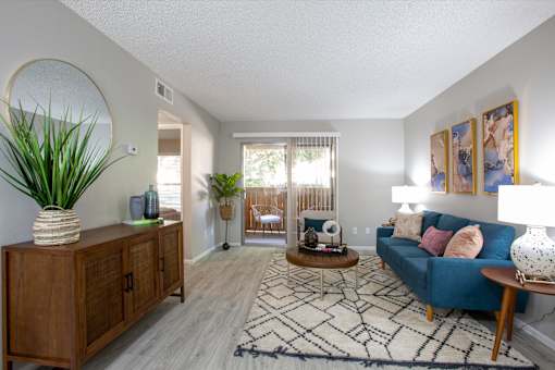 A living room with a blue couch and a wooden cabinet.
