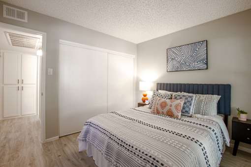 A bedroom with a large bed and a painting on the wall.