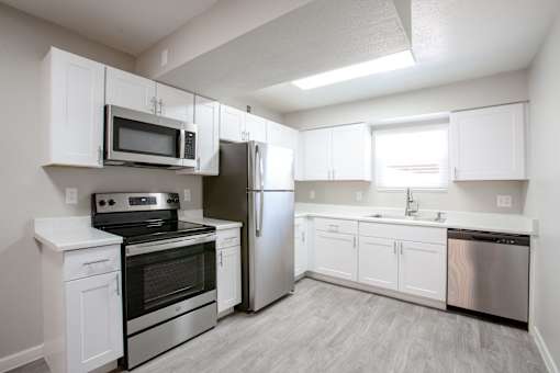 A kitchen with white cabinets and stainless steel appliances.