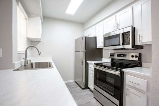 A kitchen with a black refrigerator, stove, and oven.