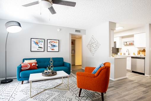 A living room with a blue couch and an orange chair.