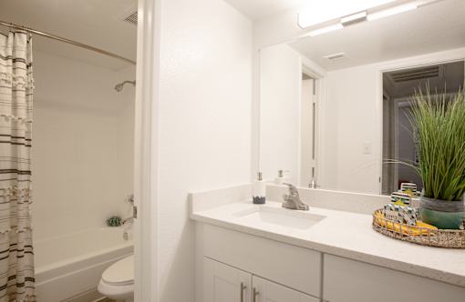 A bathroom with a white sink and a white toilet.