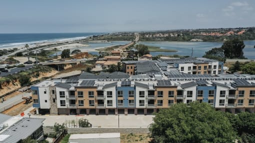 an aerial view of an apartment complex with the ocean in the background