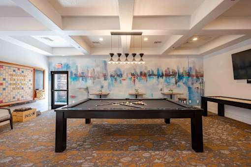 A room with a pool table and a TV.