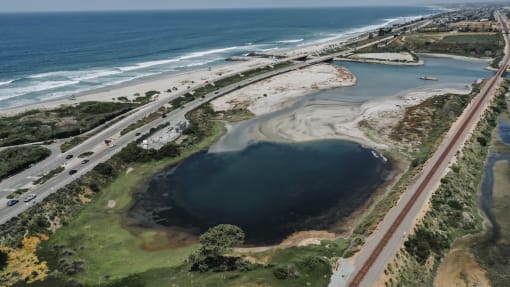 an aerial view of a body of water next to a highway and the ocean