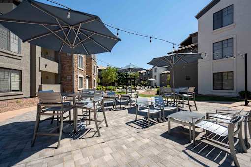 A patio with a table and chairs under umbrellas.