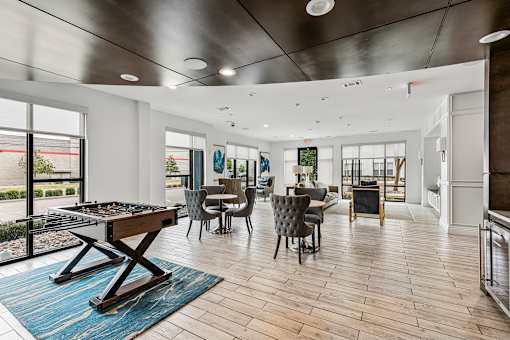 A modern dining room with a pool table and a view of the outside.