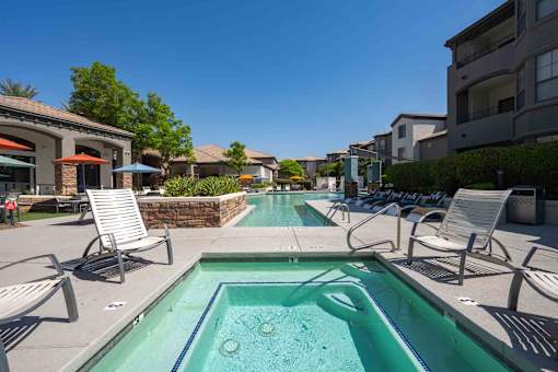 A swimming pool with a bench and a chair around it.