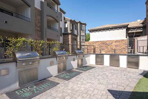 A BBQ zone is marked on the ground in front of apartment buildings.