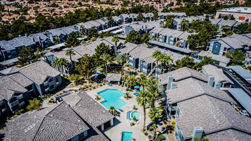 A bird's eye view of a residential area with houses and a swimming pool.