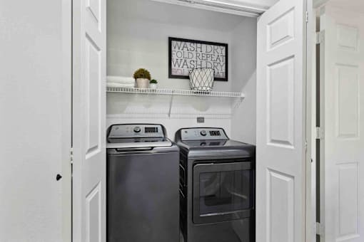 A small laundry room with a washer and dryer.