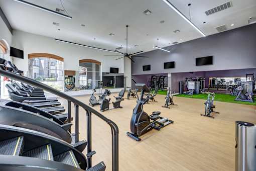 A gym with treadmills, exercise bikes, and other equipment.