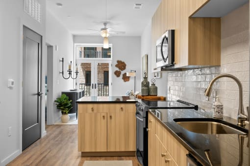 a kitchen with black countertops and wood cabinets