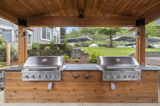 Outdoor kitchen with dual stainless steel grills at Canyon Creek Apartments, Wilsonville