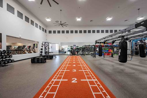 A gym with orange mats and weights.