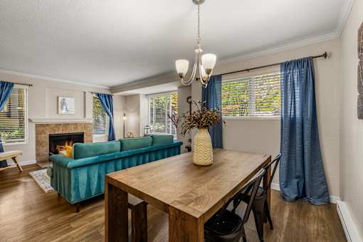 Open concept living and dining area with fireplace at Hubbard's Crossing Apartments, Kirkland, Washington
