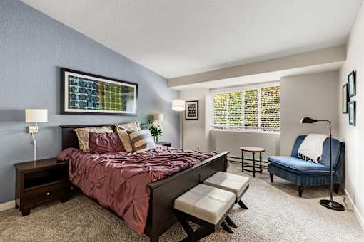 Bedroom with blue accent wall and large window at Hubbard's Crossing Apartments, Kirkland, WA 98034