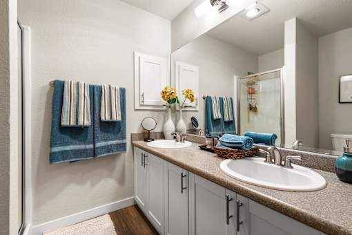 Double vanity bathroom with white cabinetry at Hubbard's Crossing Apartments, Kirkland, 98034