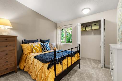 Bedroom with organized closet and natural light at Hubbard's Crossing Apartments, Kirkland