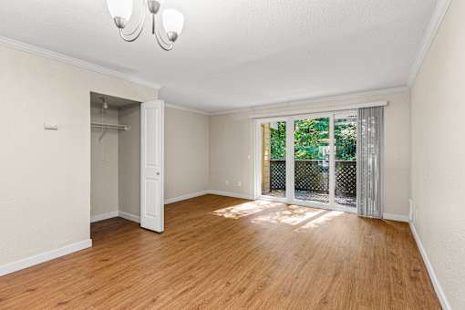Spacious bedroom with patio access and wood flooring at Hubbard's Crossing Apartments, Kirkland, WA