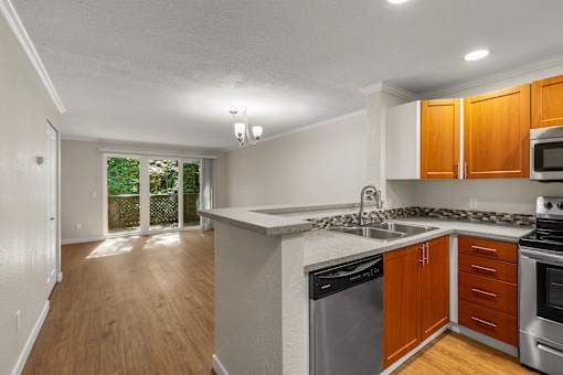 Open kitchen with breakfast bar and wood flooring at Hubbard's Crossing Apartments, Washington
