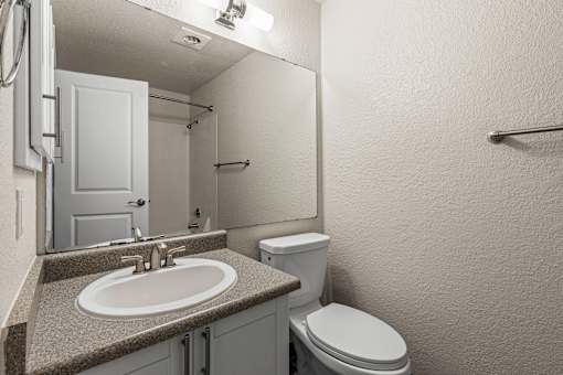 Bathroom with white vanity and shower tub combo at Hubbard's Crossing Apartments, Kirkland, Washington