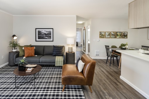 Living room with modern sofa and dining space at Canyon Creek Apartments, Wilsonville, Oregon