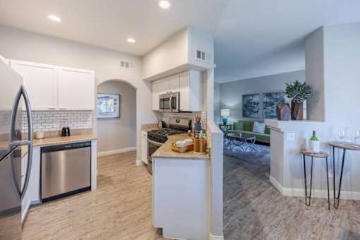 A modern kitchen with a refrigerator, oven, and microwave.
