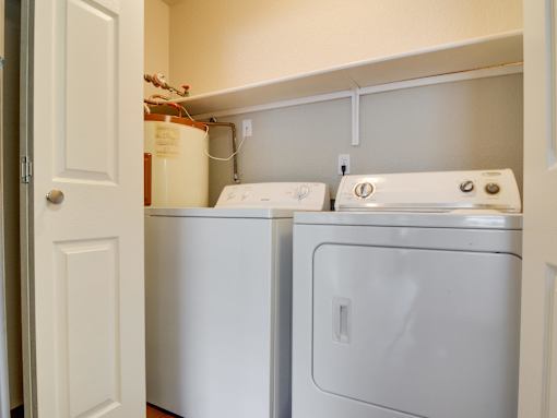 A white washing machine and dryer in a small laundry room.